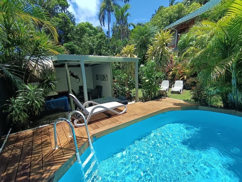 拉罗汤加穆里度假公寓的房屋旁带椅子的游泳池