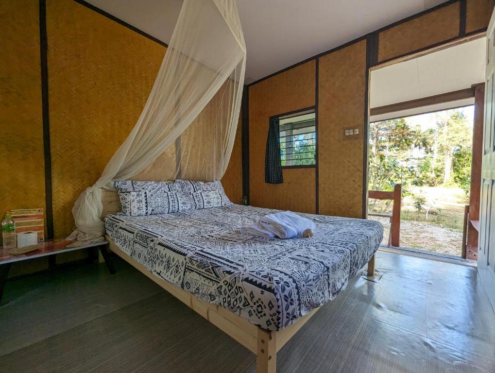 高兰Neverland Beach Village Bungalows的一间卧室配有一张带天蓬的床