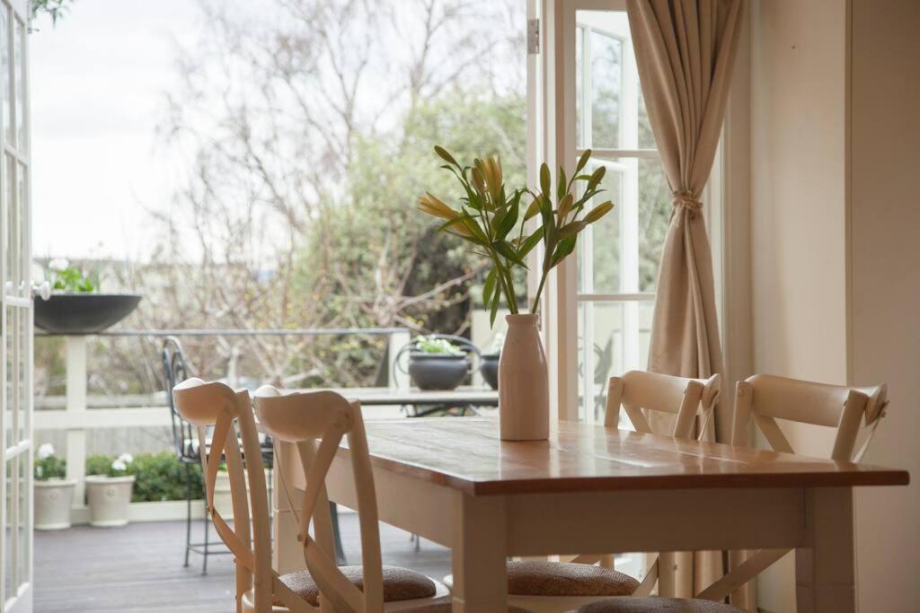 霍巴特Writer's Cottage, luxurious oasis in the heart of North Hobart的餐桌、椅子和窗户