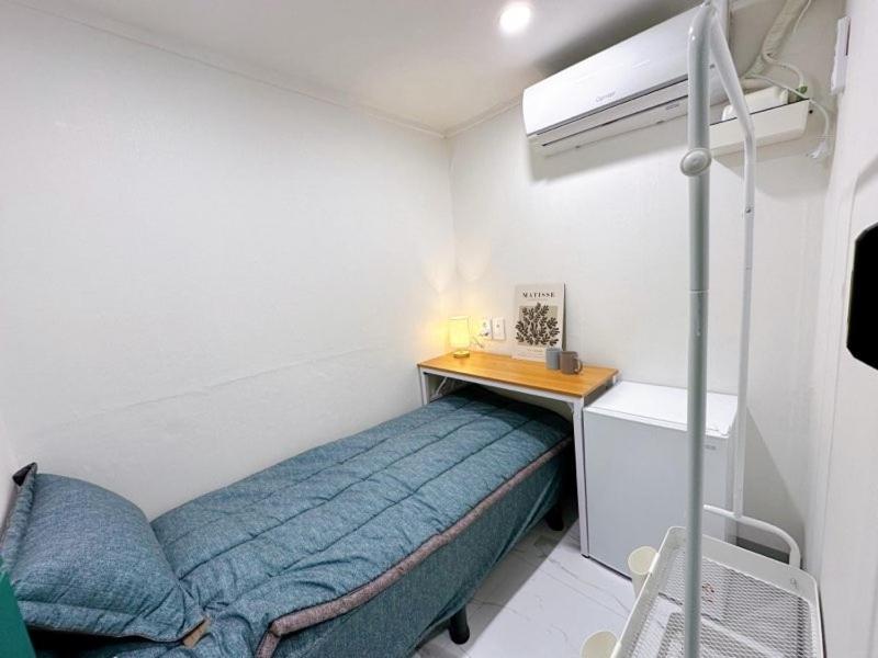 首尔Stay 2002的一间小卧室,配有一张床和一张书桌