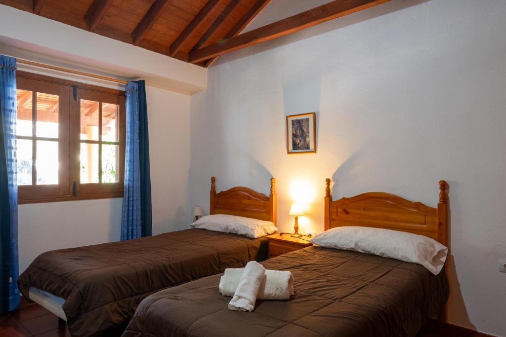 埃尔米瓜Casa Rural Nuevitas I的两张床位于带窗户的房间内