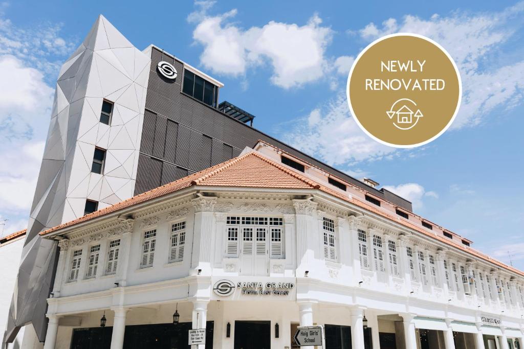 新加坡Santa Grand Hotel East Coast a NuVe Group Collection的白色的建筑,上面有一个钟楼