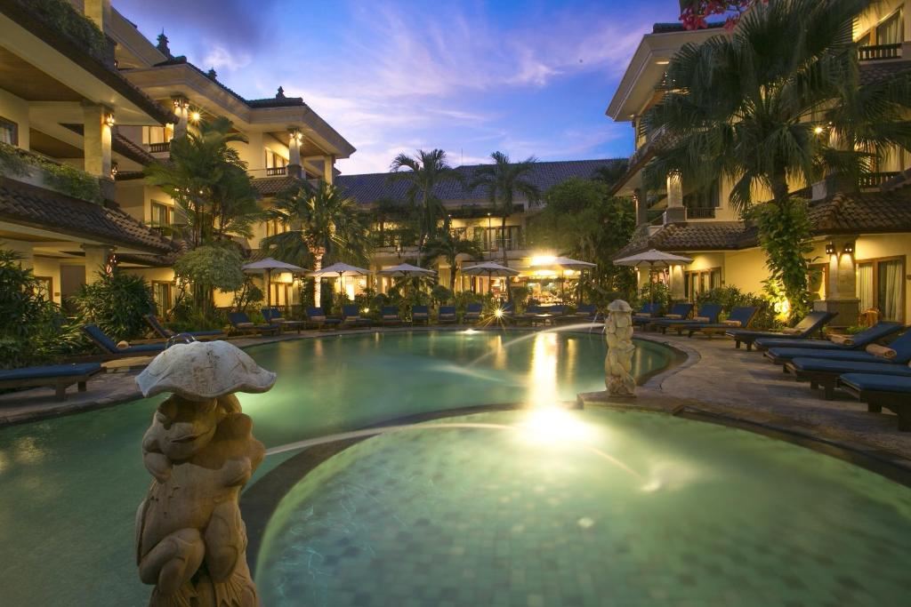 沙努尔帕瑞吉塔度假酒店及水疗中心的度假村的游泳池,中间有熊雕像