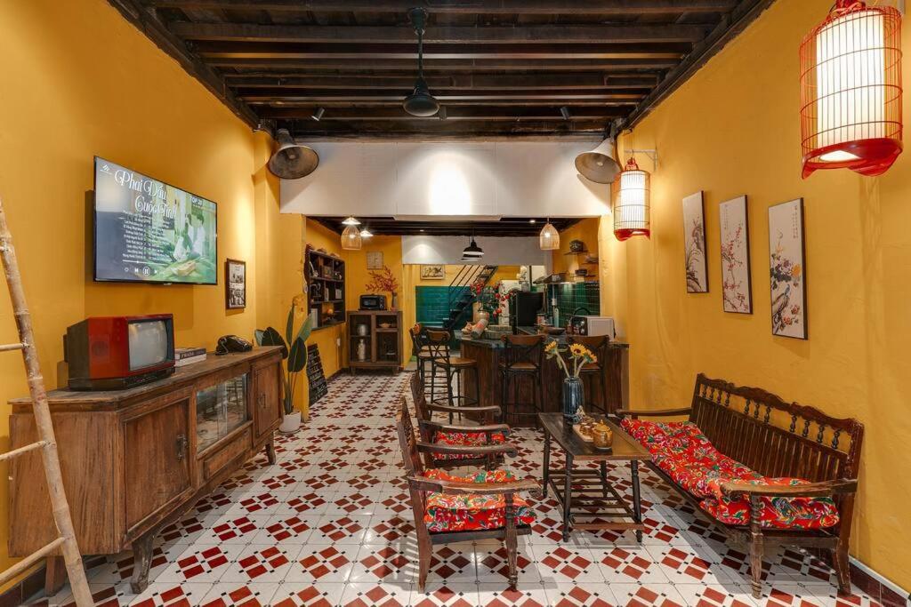 胡志明市Ben Thanh_Unique Vietnamese cultural house_Bathtub的客厅设有黄色的墙壁和桌椅