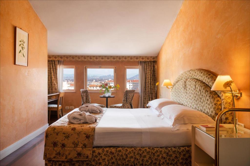 佛罗伦萨亚德里亚海大酒店的一间设有大床和窗户的酒店客房