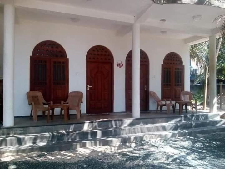 哈巴拉杜瓦Sea Garden Beach Resort的一座带木门和椅子的房子和一个游泳池