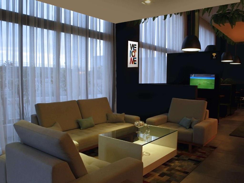 帕尔马斯ibis Styles Palmas的客厅配有沙发、椅子和电视