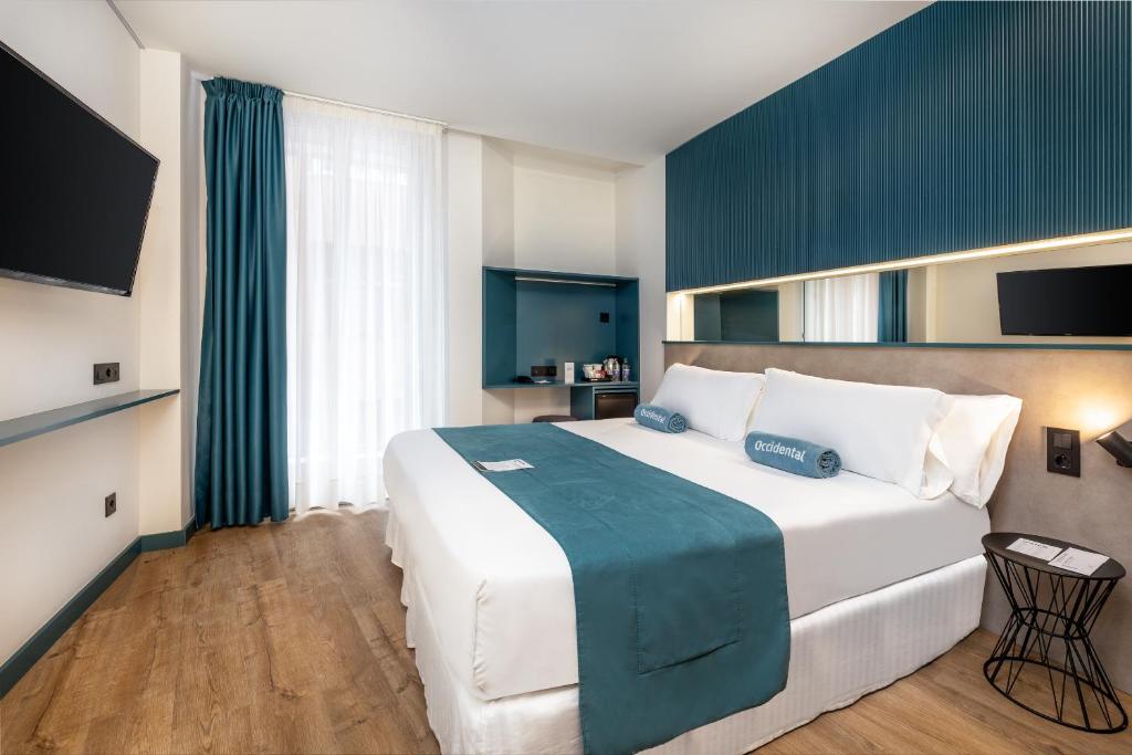 大加那利岛拉斯帕尔马斯Occidental Las Canteras的一间卧室配有一张大白色床和蓝色毯子