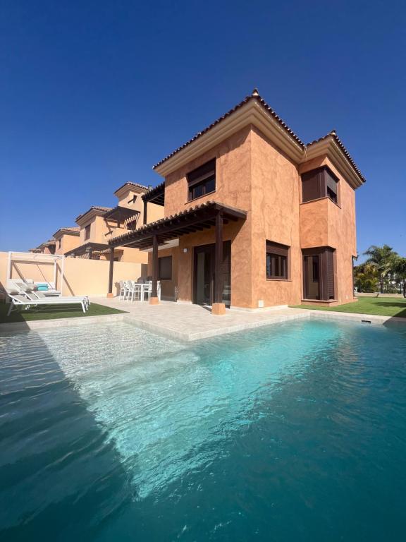 圣米格尔德阿沃纳Villa Saona Golf的一座房子前面设有游泳池