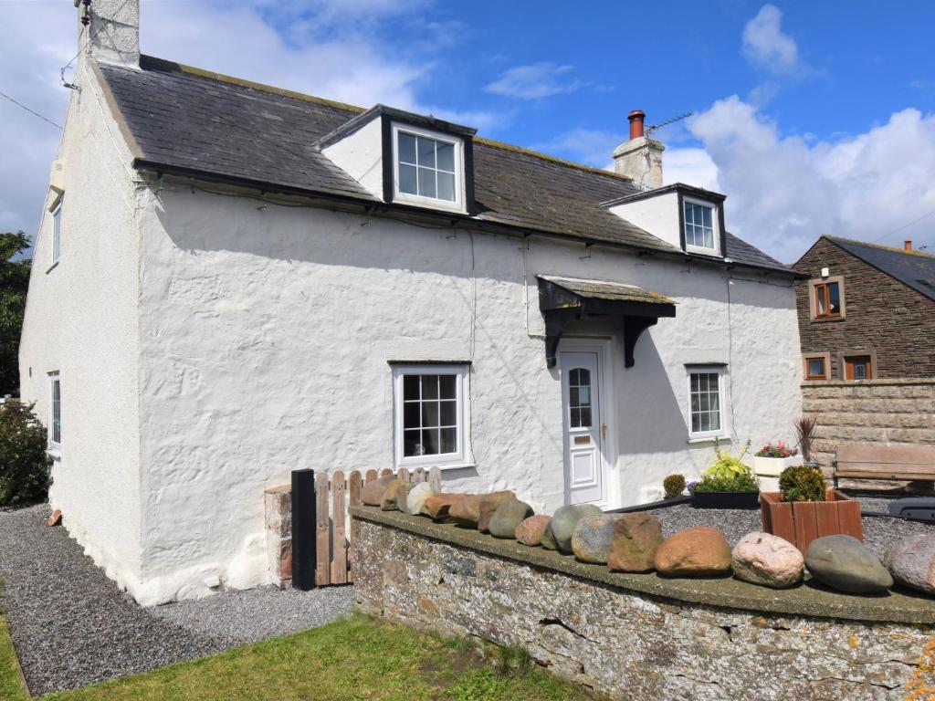 Mawbray2 bed property in Mawbray Cumbria SZ214的前面有岩石的白色房子