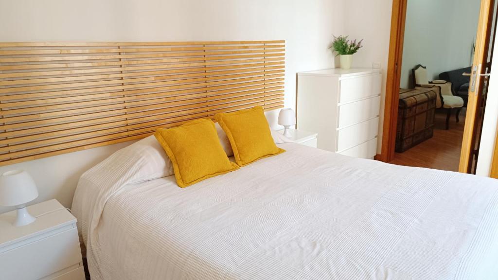 卡尼索Refúgio Garajau Madeira的卧室配有白色床和2个黄色枕头
