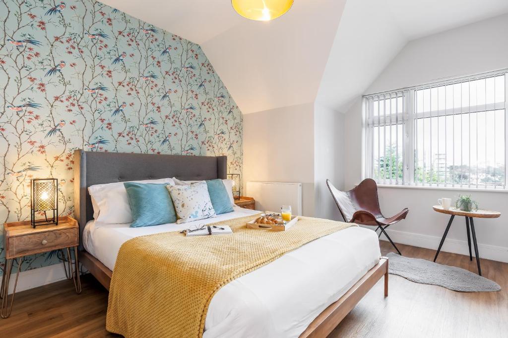 伯恩茅斯Sea Breeze Apartments的一间卧室配有一张床和一张带花卉壁纸的墙壁