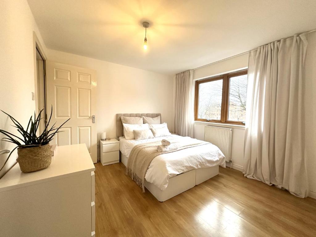 格拉斯哥Private room with en-suite and parking in shared flat的白色的卧室设有床和窗户