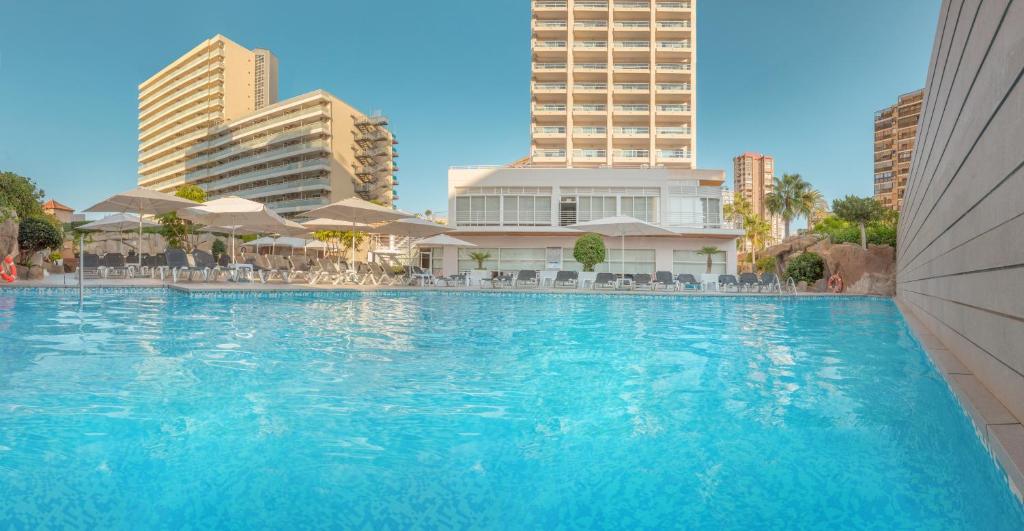贝尼多姆Hotel RH Victoria & Spa的一座大型游泳池,其建筑背景为: