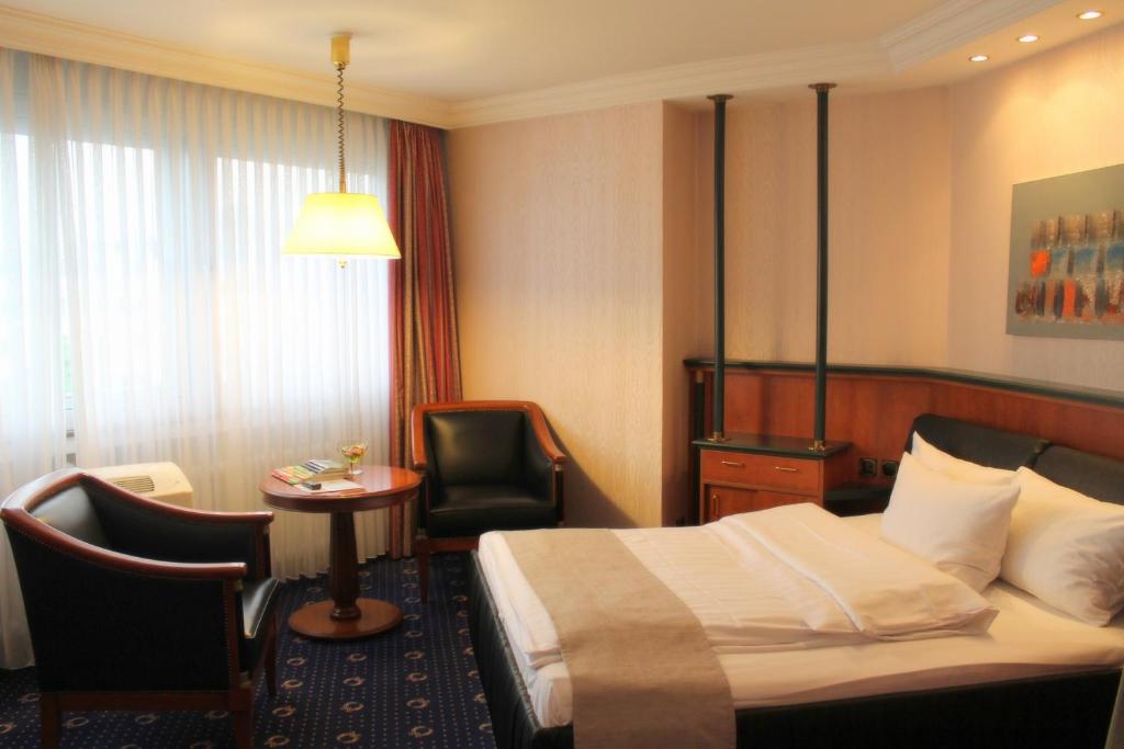 科隆多姆阿帕特尔酒店的配有床、椅子和桌子的酒店客房
