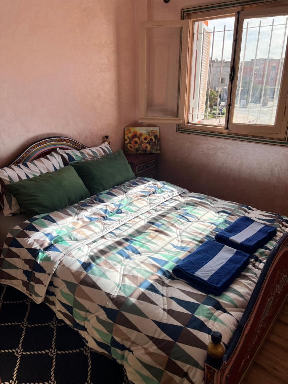 马拉喀什Julie's AIRPORT Apartment的一间卧室配有一张带床罩的床和窗户