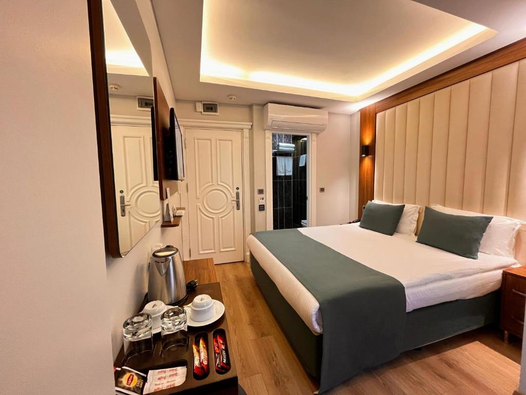 伊斯坦布尔黑色郁金香酒店的一间卧室配有一张大床和一张带餐具的桌子