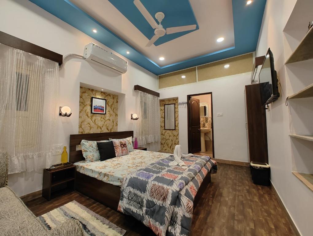 乌代浦Leisure Homestay的一间卧室设有一张床、一台电视和天花板