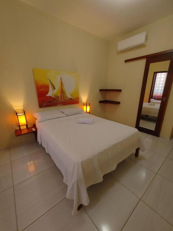 帕拉库鲁Pousada Viva Praia的一间卧室配有一张带两盏灯的大型白色床。