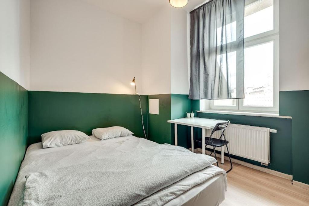 卡托维兹Hostel Kattowitz的一间卧室配有一张床、一张书桌和一个窗户。