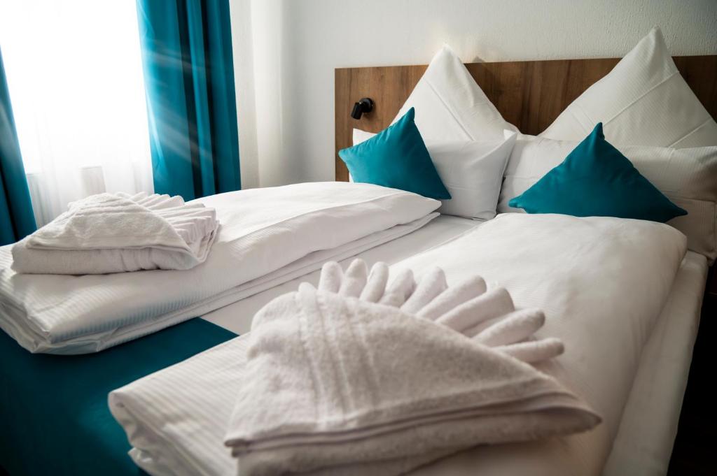 斯图加特Hotel Hansa Stuttgart City的两张带白色床单和蓝色枕头的床