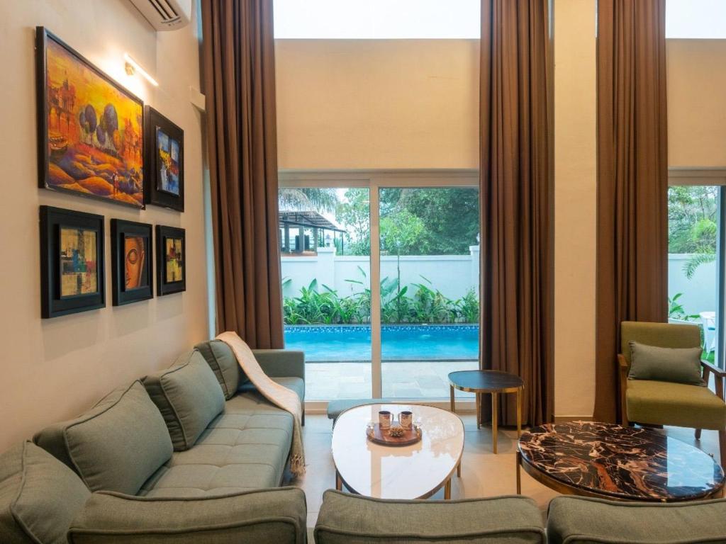 果阿旧城Jade 4BHK Private Pool Villa by Le Pension Stays的客厅配有沙发和桌子