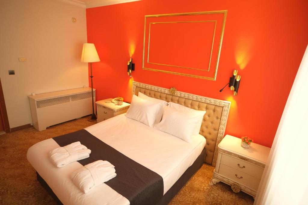 迪亚巴克尔Malabadi Hotel的一间卧室配有一张橙色墙壁的床