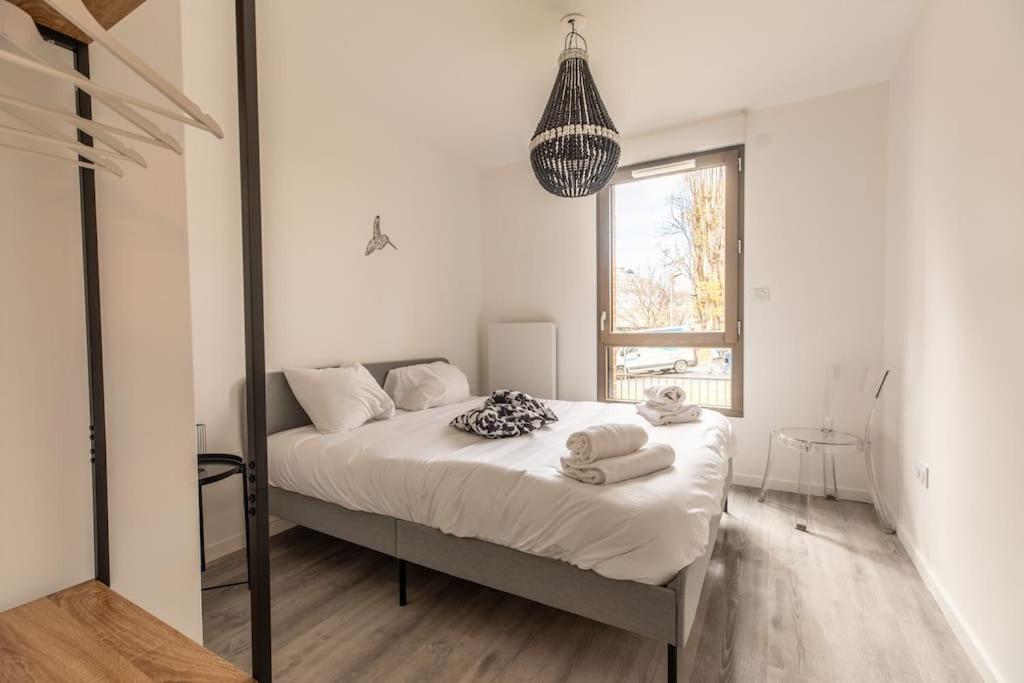 克莱蒙费朗Le Vercingetorix centre +Parking的一间卧室配有一张带白色床单的床和一扇窗户。