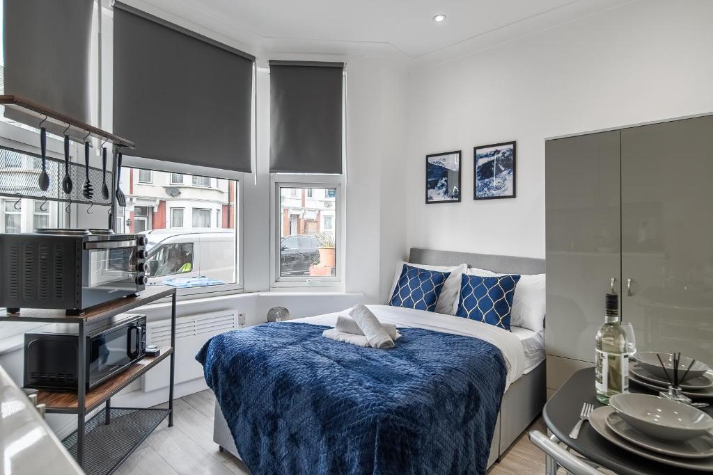 伦敦Modern Studio Rooms in Zone 2 London的一间卧室配有一张带蓝色毯子的床