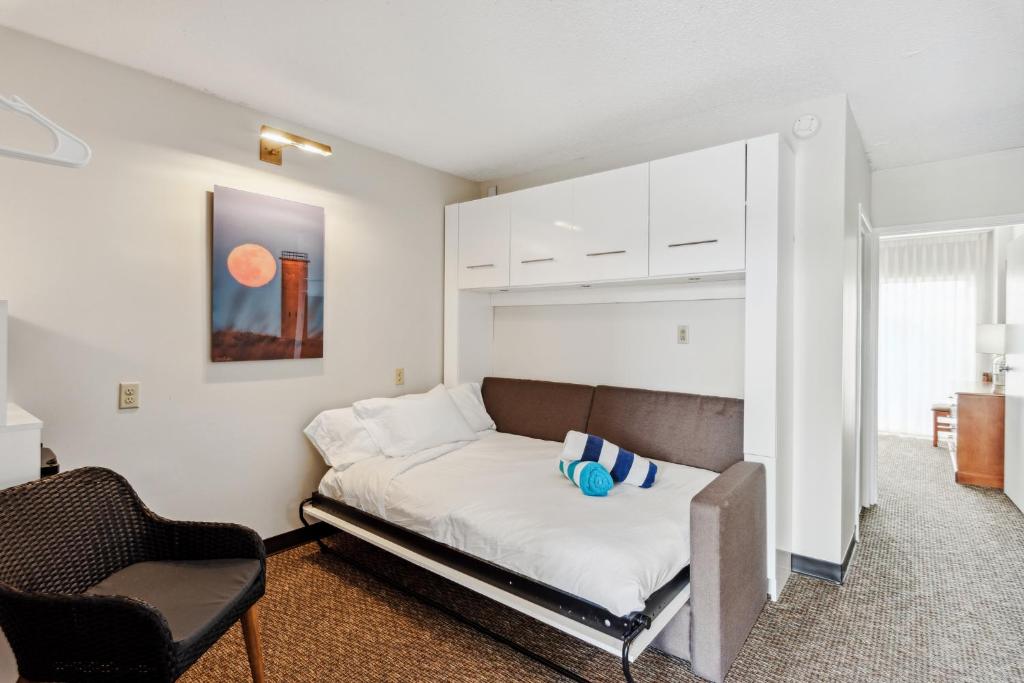 柏斯海滩Cape Suites Room 8 - Free Parking! Hotel Room的一间卧室配有一张床和一把椅子