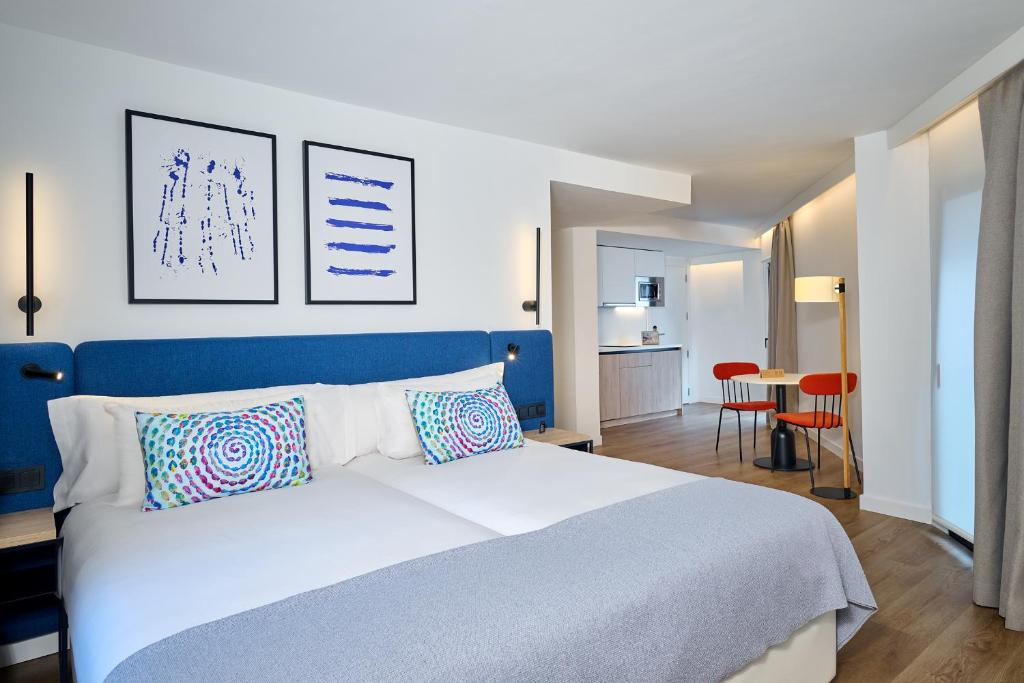 格拉纳达Apartamentos Luna Suites Granada的卧室配有白色的床和蓝色床头板