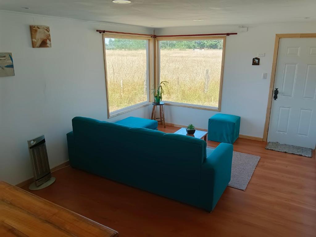 弗鲁蒂亚尔Cabaña familiar的客厅设有蓝色的沙发和2扇窗户。