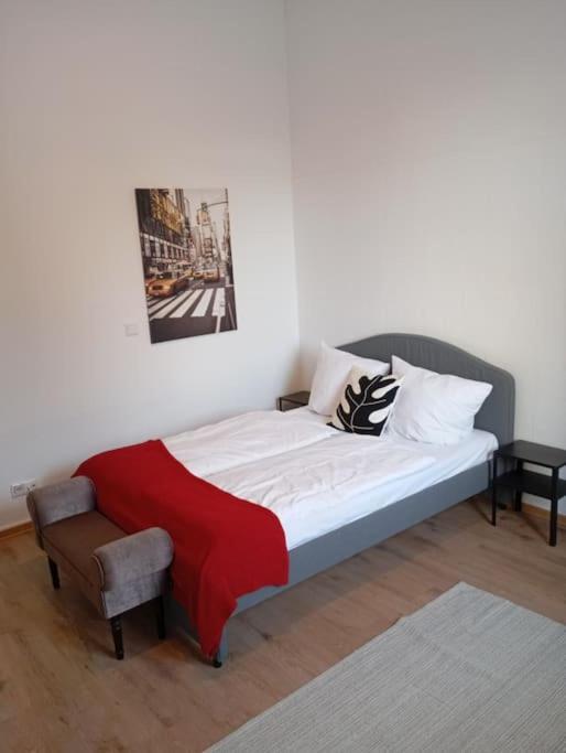 科布伦茨Apartment Koblenz nähe Uni und BWZK的一张红色毯子的床和一把椅子