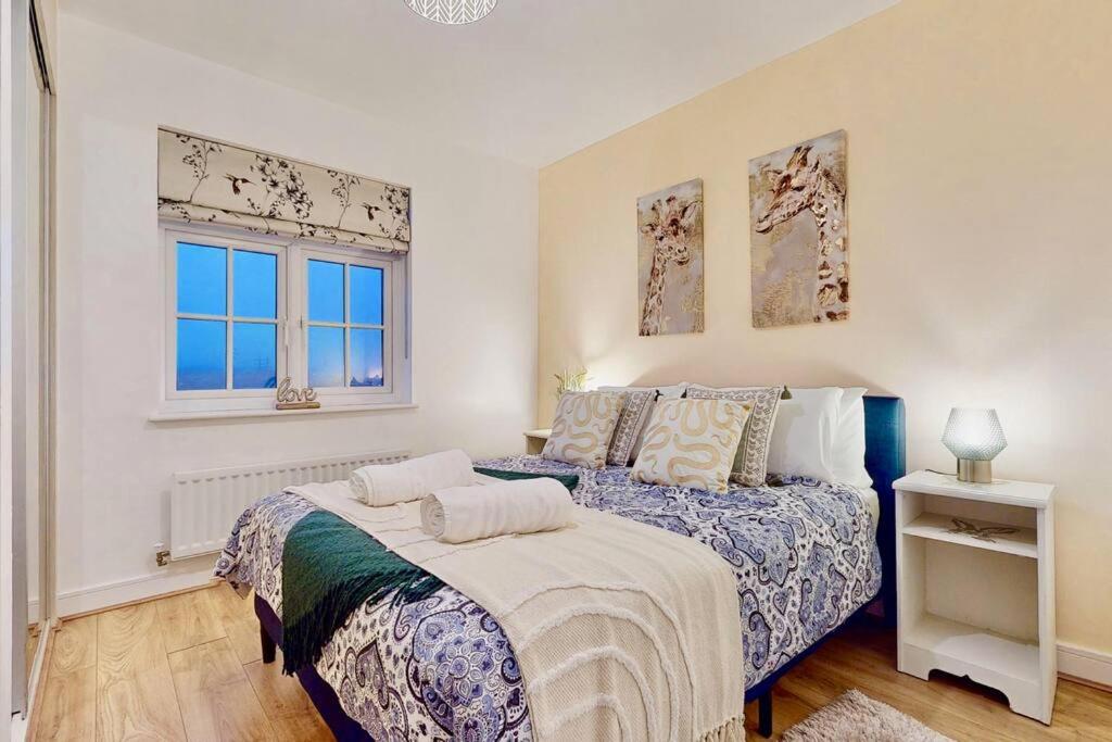 SwanscombeCandy Dene, Top Floor Apartment的一间卧室设有两张床和两个窗户。