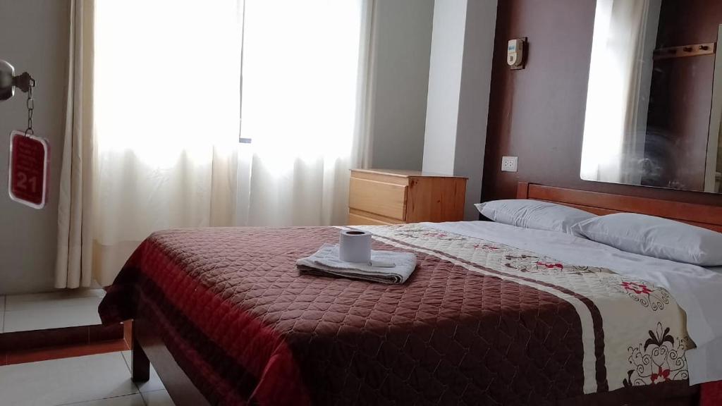 利马Plaza inn的一间卧室配有一张床,床上有毛巾