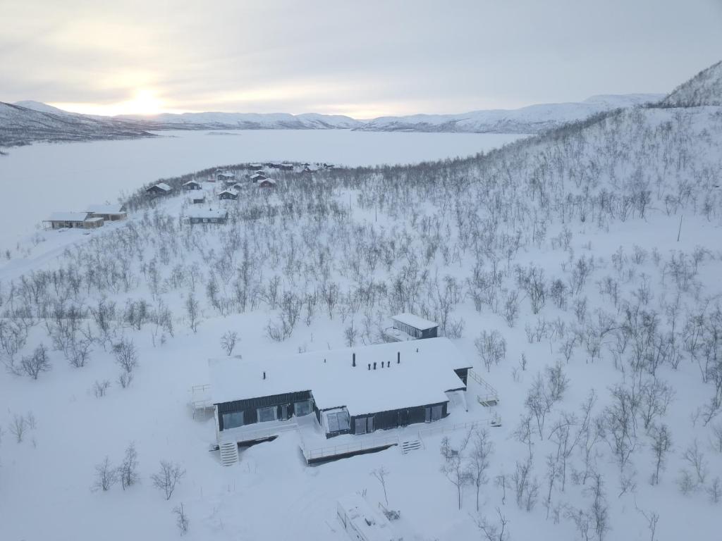 基尔匹斯扎我维Aurora View Lapland, Sky View Bedroom & Jacuzzi的雪中房屋的空中景观