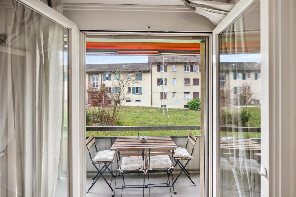 苏黎世Cozy 2 Bedroom Apartment in Zurich的阳台的天井配有桌椅