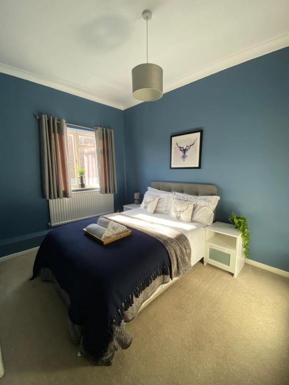 珀肖尔Pershore Rooms at The Star的一间卧室配有一张带蓝色墙壁的大床