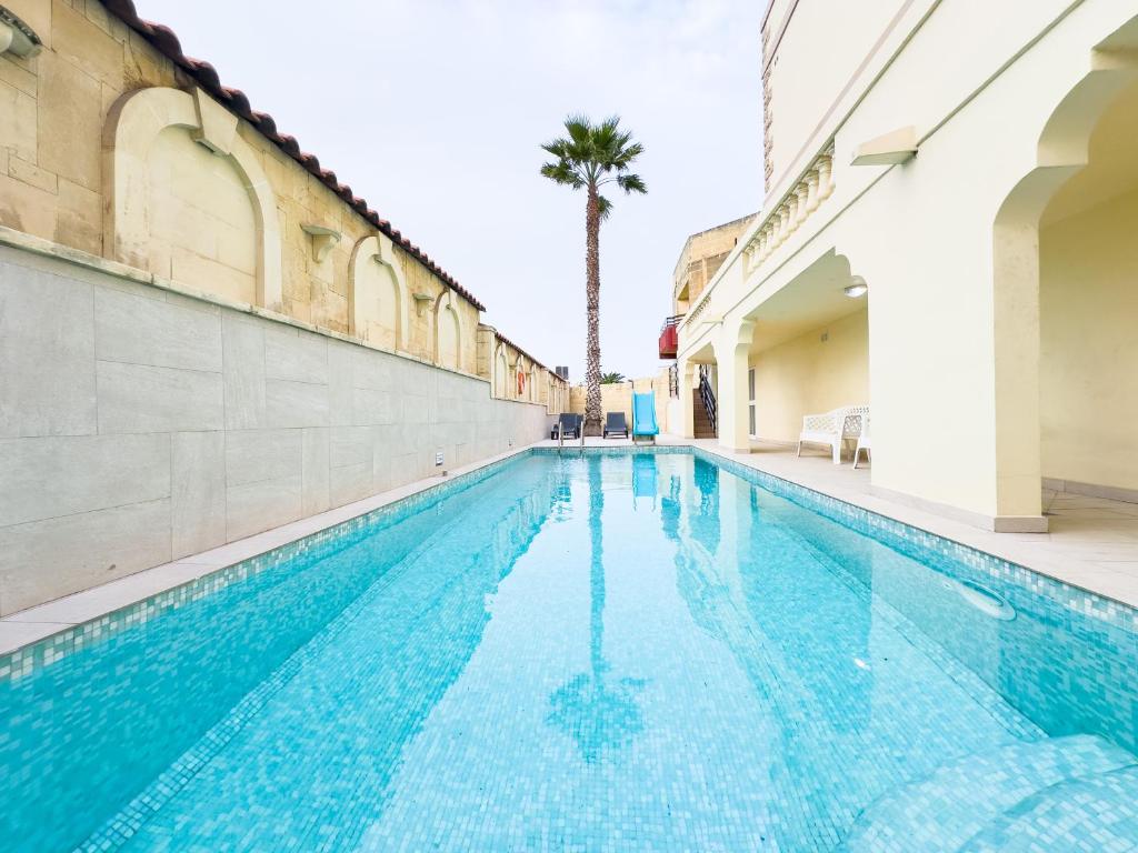 圣朱利安斯Villa in St Julian's with Private Pool的一座棕榈树建筑的游泳池