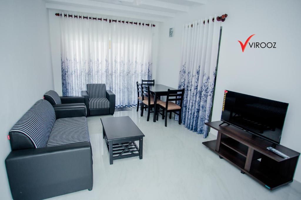 BorupaneVirooz Residence Rathmalana 2 Bedroom Apartment的带沙发、电视和桌子的客厅