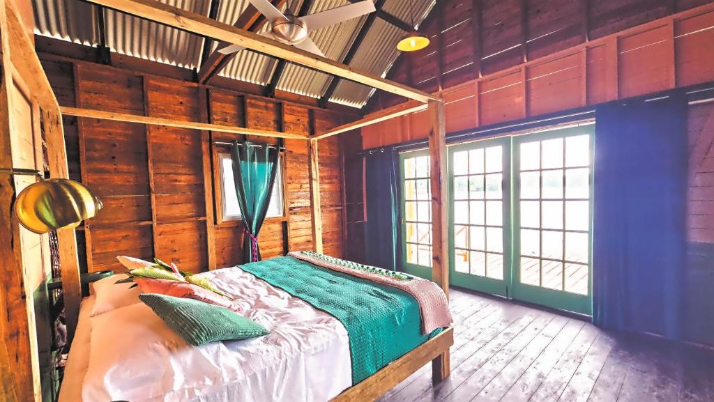 博卡斯德尔托罗The Sea Monkey的卧室配有一张床铺,位于带木墙的房间内