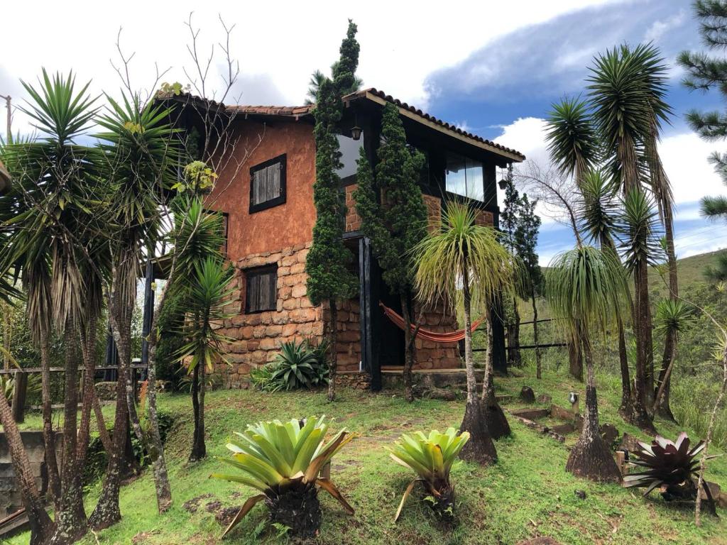 拉夫拉斯诺瓦斯Chalés Serra do Trovão的前面有棕榈树的房子