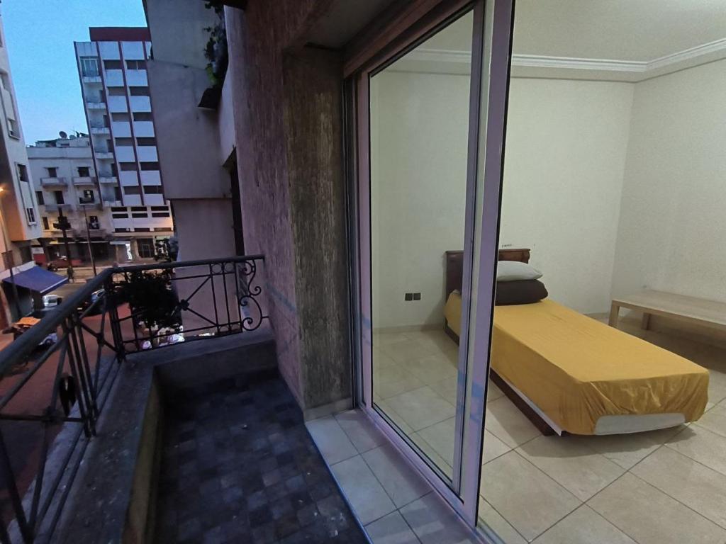 卡萨布兰卡Casablanca Geusthouse的客房设有带玻璃窗户和阳台床铺的客房