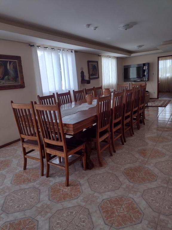 圣若昂-德雷Aconchego Mineiro的一间带木桌和椅子的用餐室
