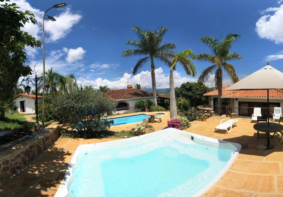 布卡拉曼加Finca Hacienda Casa Prada的一座带房子的庭院内的大型游泳池
