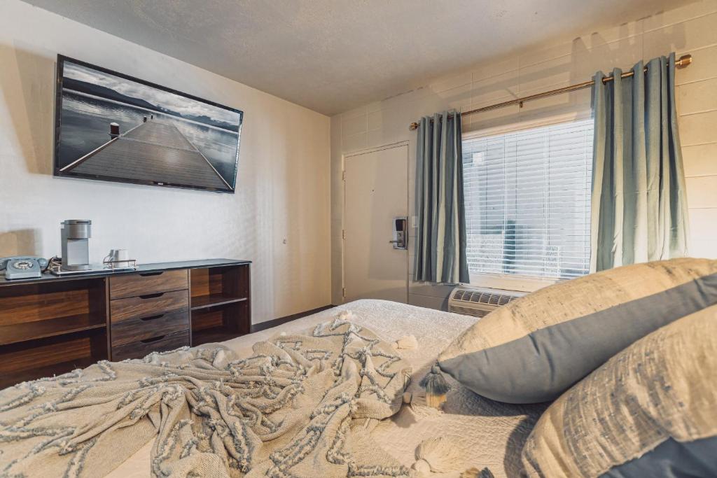 米苏拉Bel Aire Motel的卧室配有一张床铺,墙上配有电视