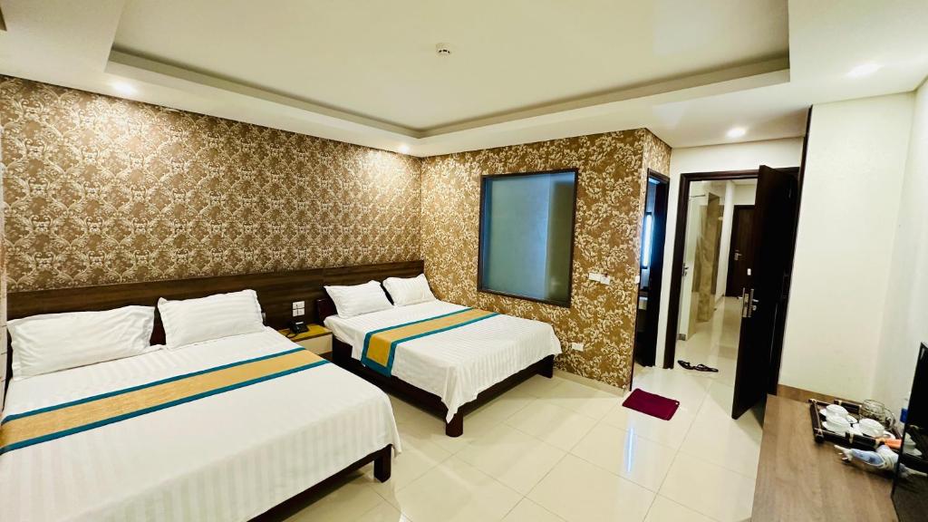 富国May Hotel Sonasea Phu Quoc的酒店客房设有两张床和电视。