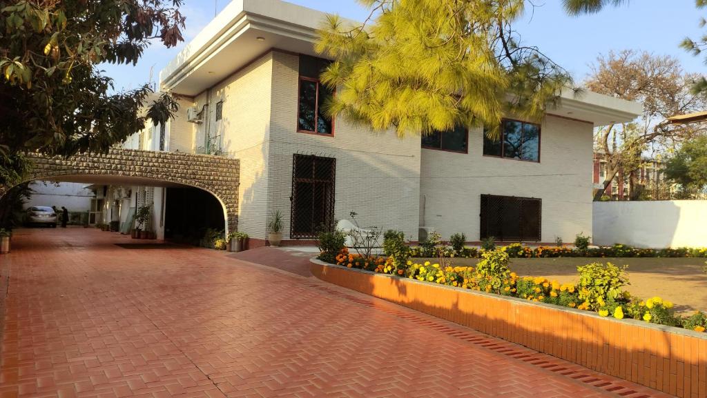 伊斯兰堡Aleph Islamabad Guest House的前面有砖砌的走道和鲜花的建筑