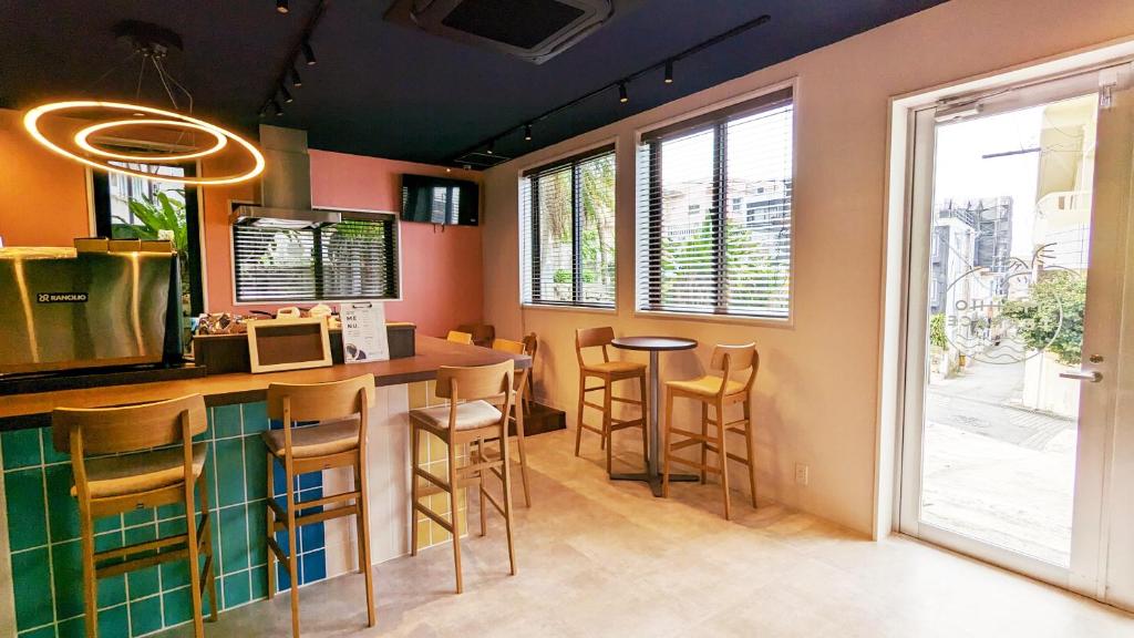 宫古岛MAHHO TERRACE MIYAKO的厨房设有带凳子和窗户的酒吧
