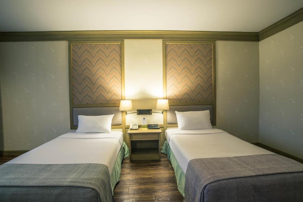 โรงแรมมุกดาหารแกรนด์的酒店客房配有两张床和一张书桌